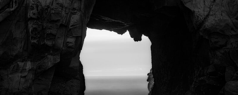 Sea cave opening with ocean view and rock